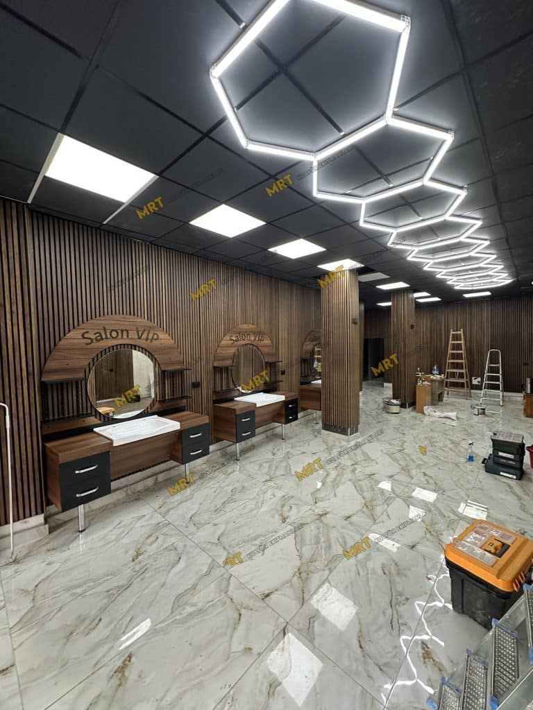 Tavan aydınlatmaları ve ahşap duvar panelleriyle berber salonu